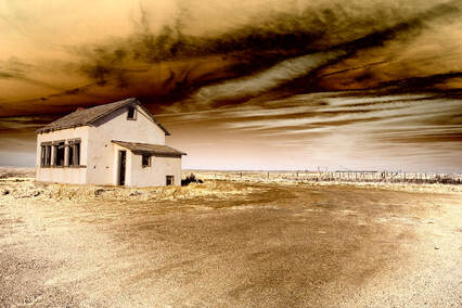 A sepia image of a tan house with brown trim, flat, barren land, and a brown sky after a dust storm.